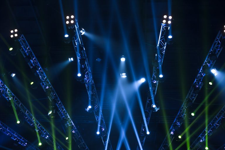 Stage lighting beams and trusses with blue and green spotlights in action